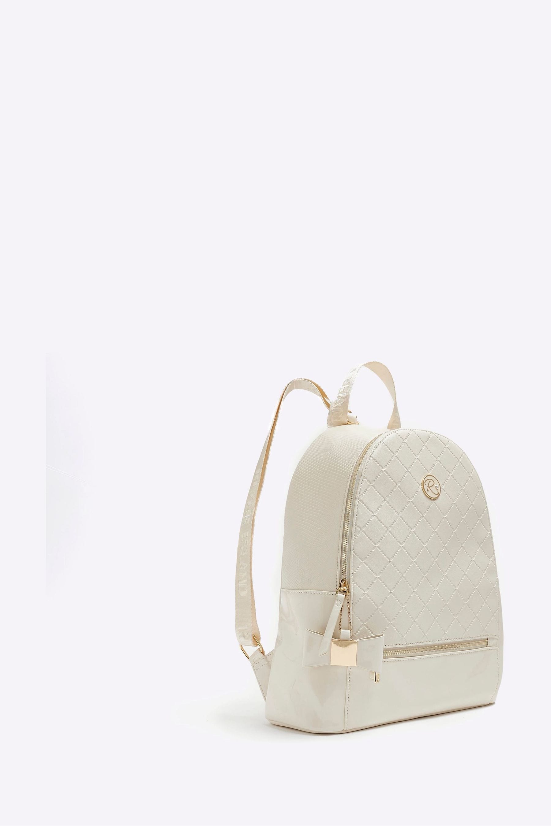 Buy River Island Cream Girls Embossed Bow Backpack from Next Luxembourg