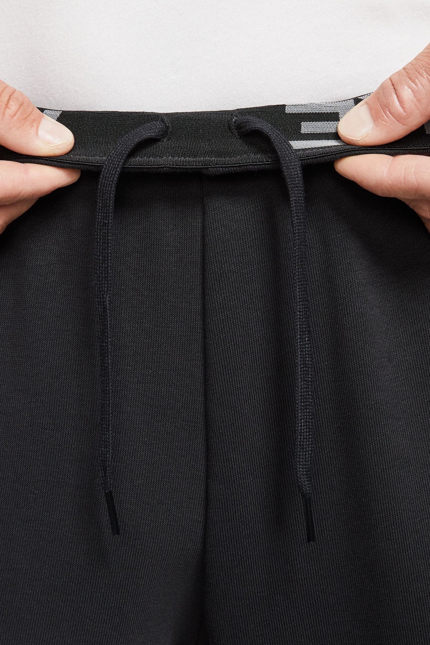 Nike training tapered fleece pants in black best sale