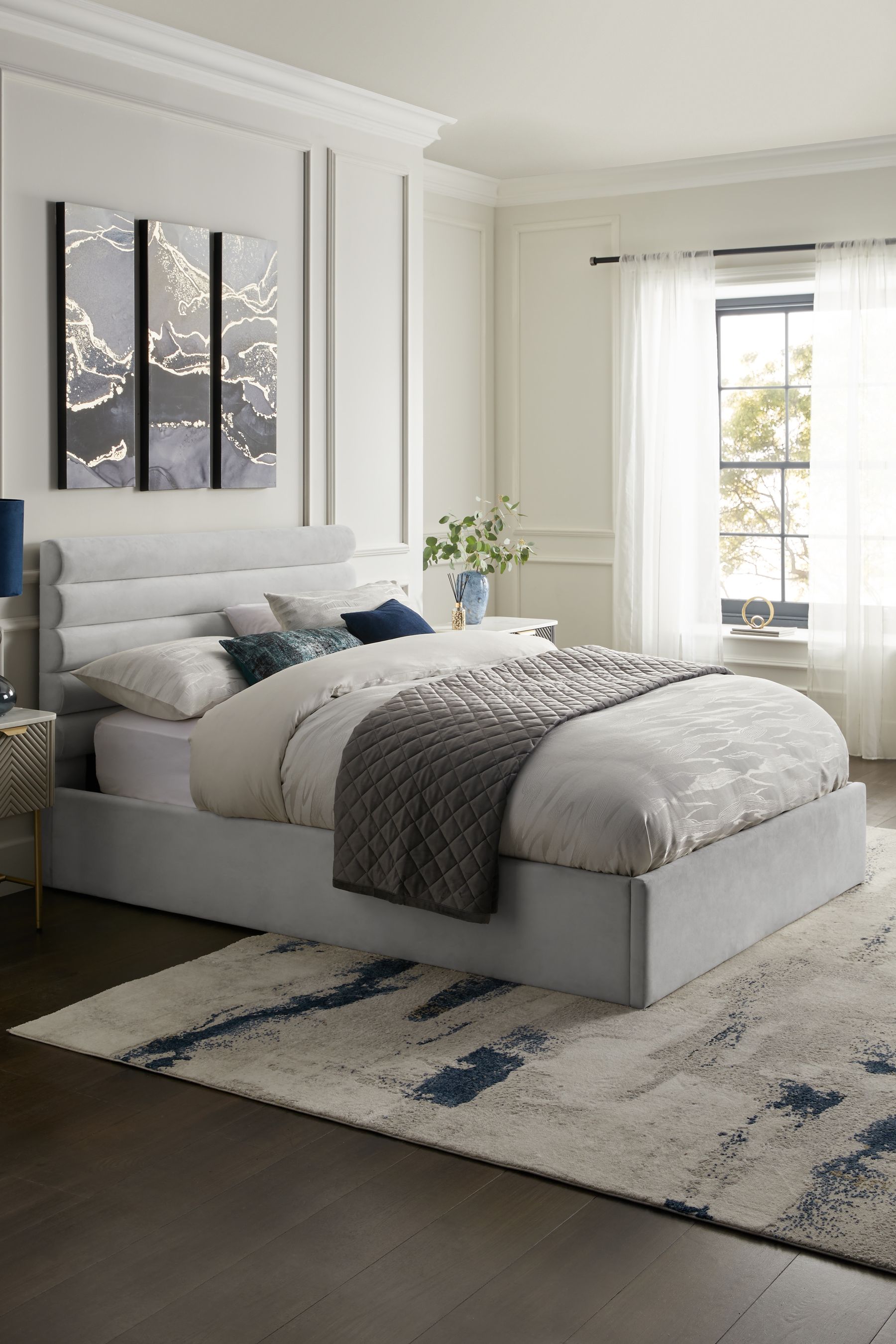 Grey upholstered bed store with white nightstands
