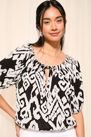 Friends Like These Black and White Ikat Tie Neck Bubble Hem Puff Sleeve Top - Image 1 of 4