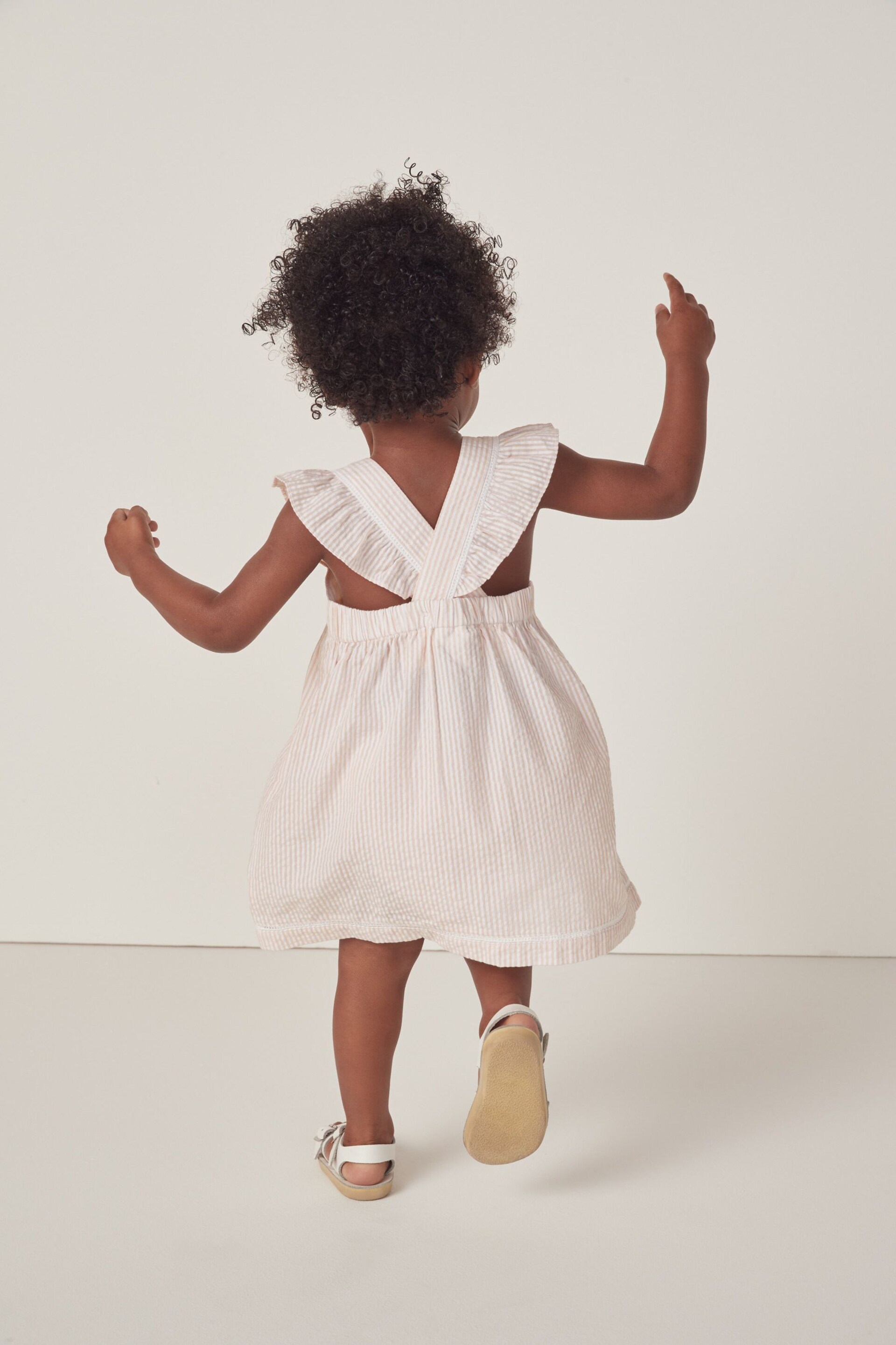 The White Company Pink Organic Cotton Seersucker Stripe Ruffle Pinafore Dress - Image 1 of 4