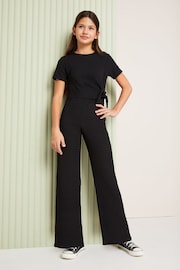 Lipsy Black Tie Side Crinkle Texture Jersey Jumpsuit (5-16yrs) - Image 1 of 4