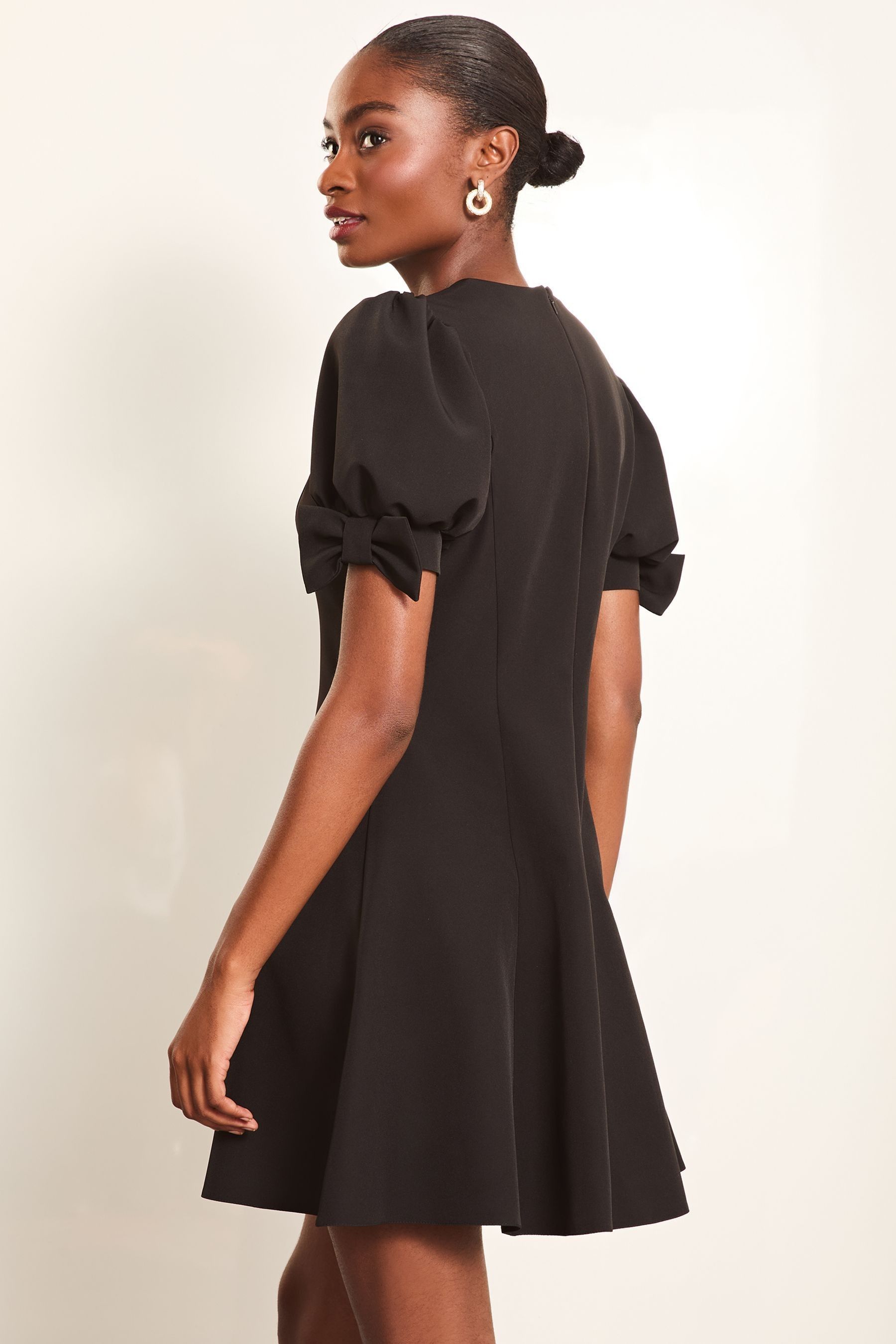 Buy Lipsy Black Bow Detail Puff Sleeve Skater Mini Dress from the Next UK online shop