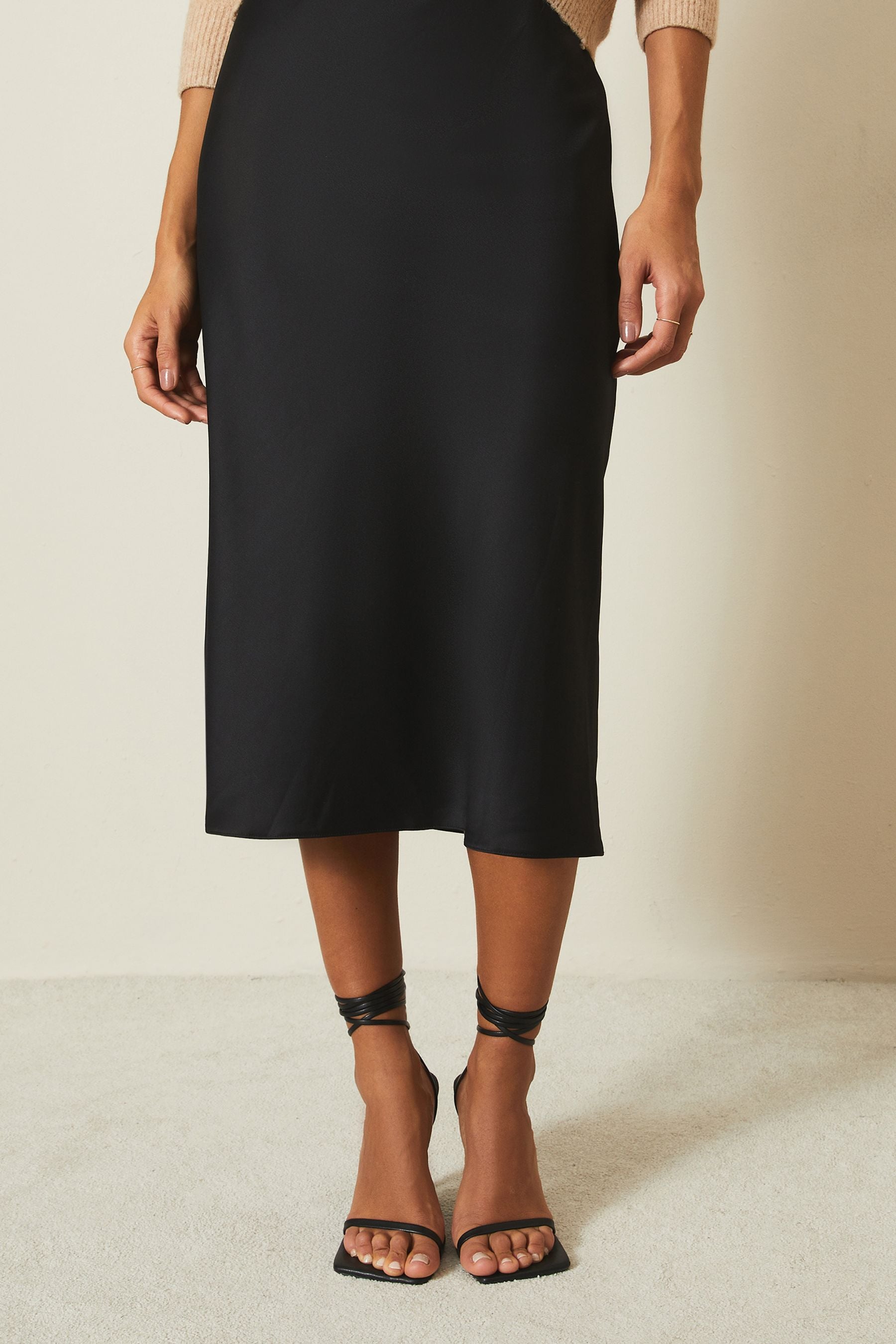 Buy Lipsy Solid Black Petite Satin Bias Cut Midi Skirt from the