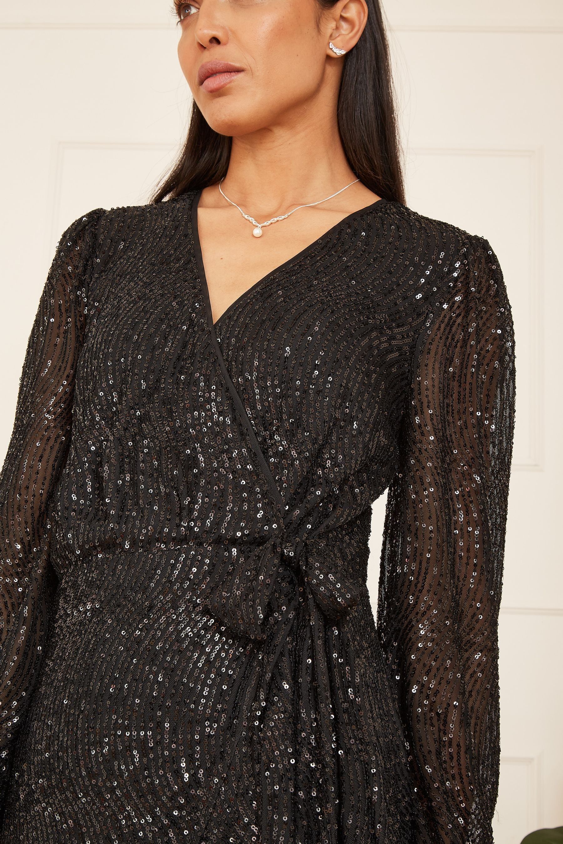 Buy Mela Black Sequin Long Sleeve Frill Wrap Dress from the Next